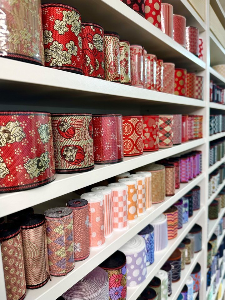 Shelves of rolled tatami-beri fabric in many colors and patterns